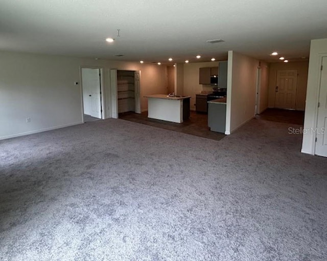 unfurnished living room featuring dark colored carpet