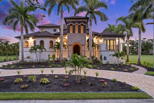 mediterranean / spanish-style home with a tiled roof and stucco siding