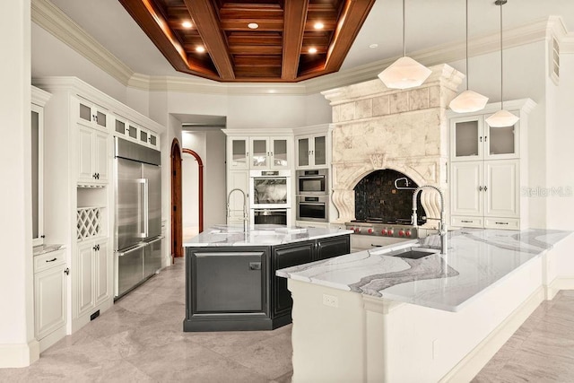 kitchen with a sink, stainless steel appliances, a spacious island, and coffered ceiling