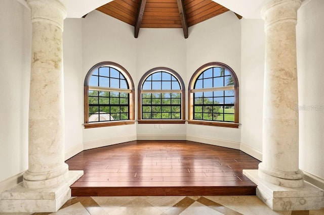 unfurnished room featuring beamed ceiling, wood ceiling, a healthy amount of sunlight, and ornate columns