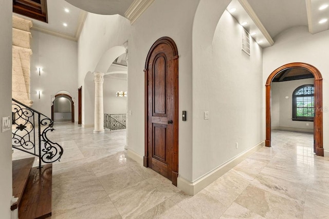 hall with arched walkways, marble finish floor, and crown molding