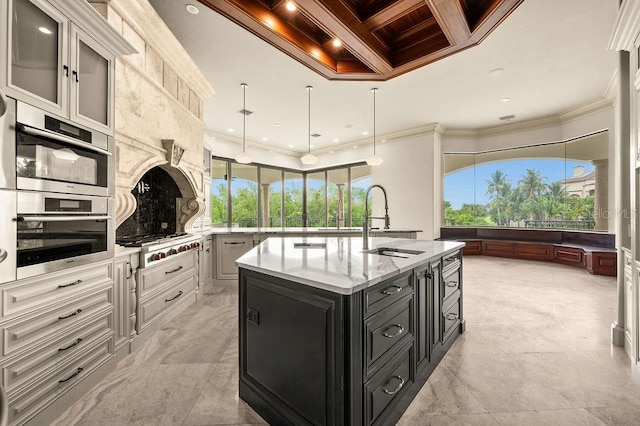 kitchen featuring decorative light fixtures, stainless steel appliances, crown molding, coffered ceiling, and a center island with sink