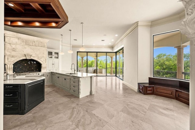 kitchen featuring gray cabinets, pendant lighting, crown molding, and a kitchen island with sink