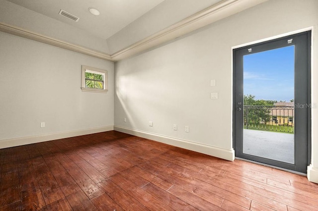 spare room featuring baseboards, visible vents, and wood-type flooring