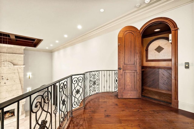 corridor featuring recessed lighting, arched walkways, wood-type flooring, and ornamental molding