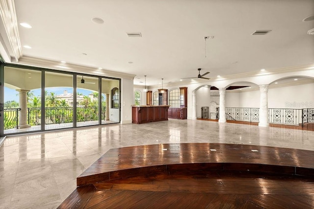 interior space with decorative columns and ceiling fan