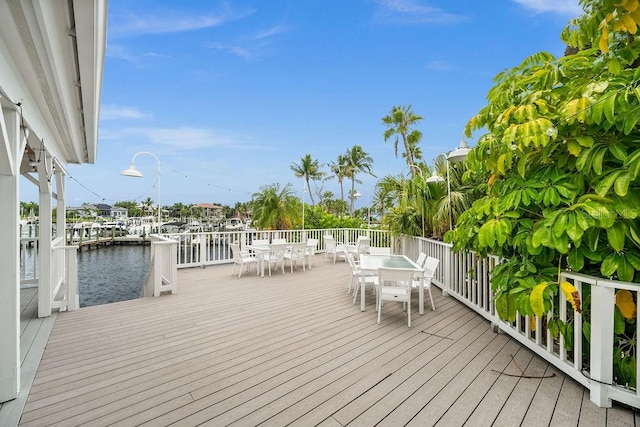 wooden deck with a water view and a boat dock