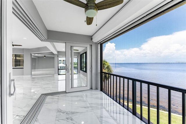 balcony featuring a water view and ceiling fan