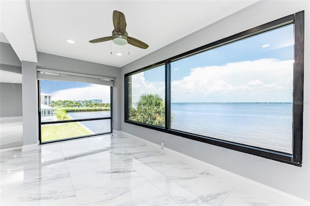 spare room featuring ceiling fan and a water view