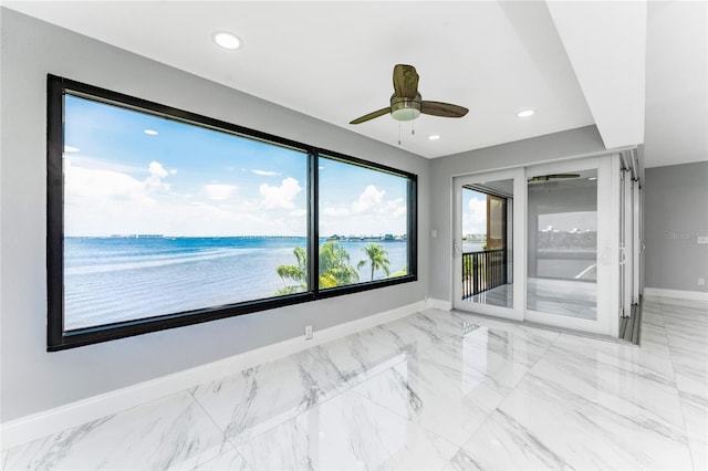 unfurnished room featuring a water view and ceiling fan