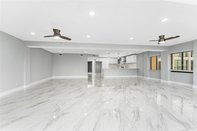 unfurnished living room featuring ceiling fan