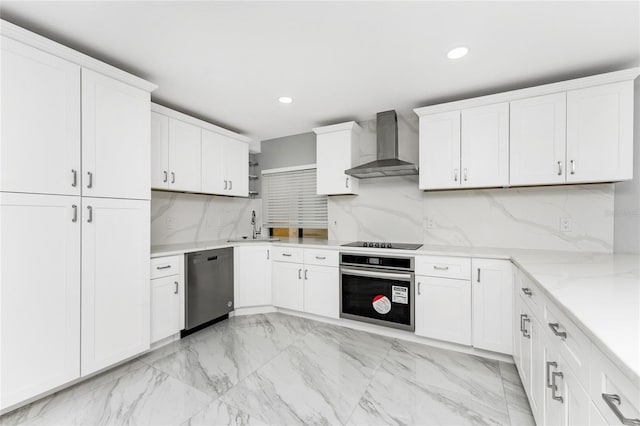 kitchen featuring backsplash, white cabinets, stainless steel appliances, and wall chimney range hood