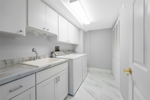 laundry room featuring cabinets, washing machine and dryer, and sink