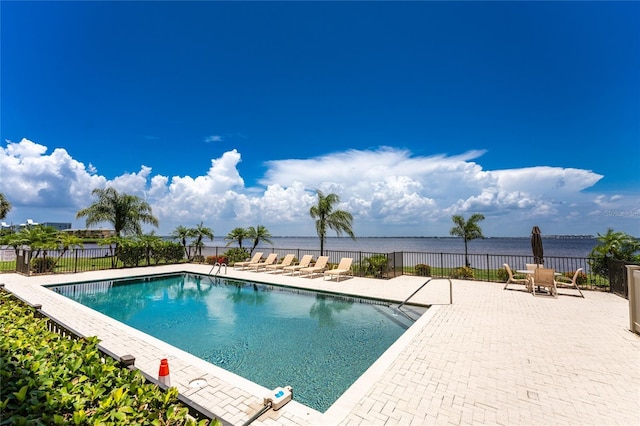 view of pool with a water view and a patio area