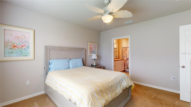 carpeted bedroom with ensuite bath and ceiling fan