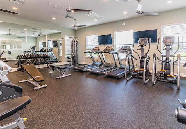 gym with a ceiling fan, plenty of natural light, and baseboards