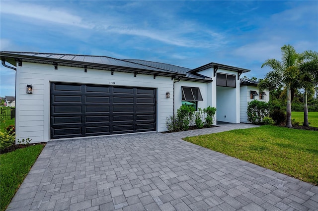 ranch-style house featuring a garage and a front lawn