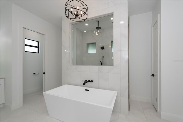 bathroom with an inviting chandelier, shower with separate bathtub, and tile walls