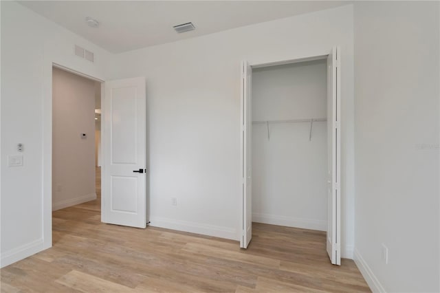 unfurnished bedroom featuring light wood-type flooring and a closet