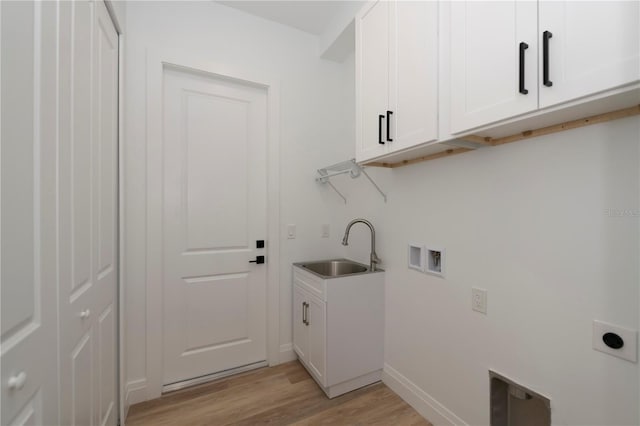 washroom with light hardwood / wood-style floors, sink, hookup for a washing machine, hookup for an electric dryer, and cabinets