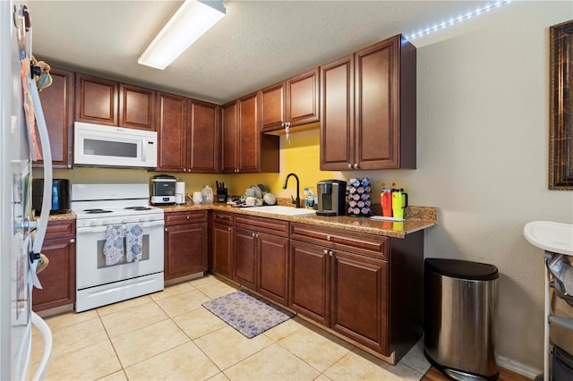 kitchen with white appliances, sink, a textured ceiling, light stone countertops, and light tile patterned flooring