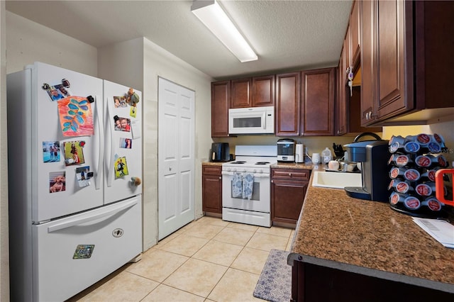 kitchen featuring sink, a textured ceiling, light tile patterned floors, and white appliances