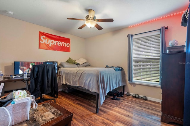bedroom with wood finished floors, baseboards, and ceiling fan