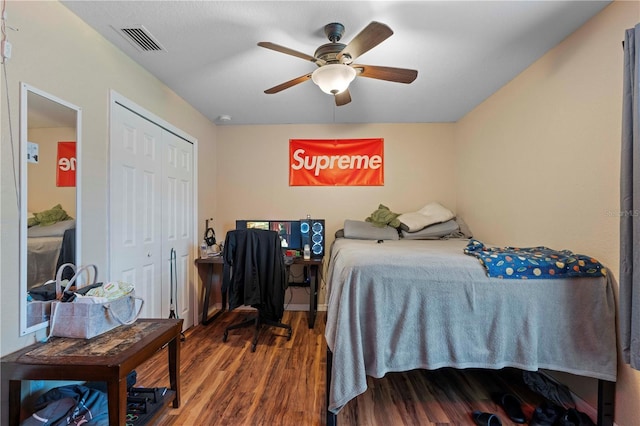 bedroom featuring wood finished floors, visible vents, a closet, and ceiling fan