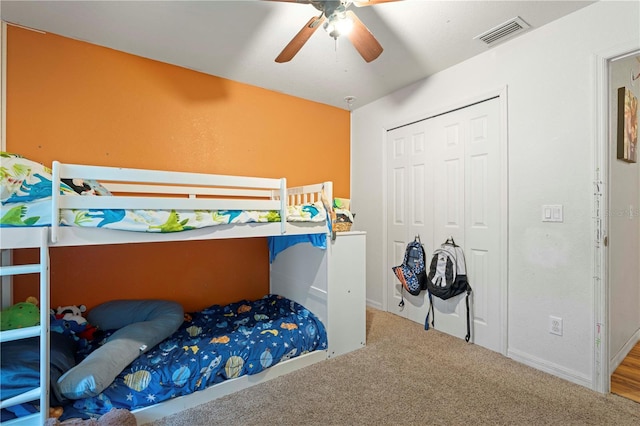 carpeted bedroom with ceiling fan and a closet