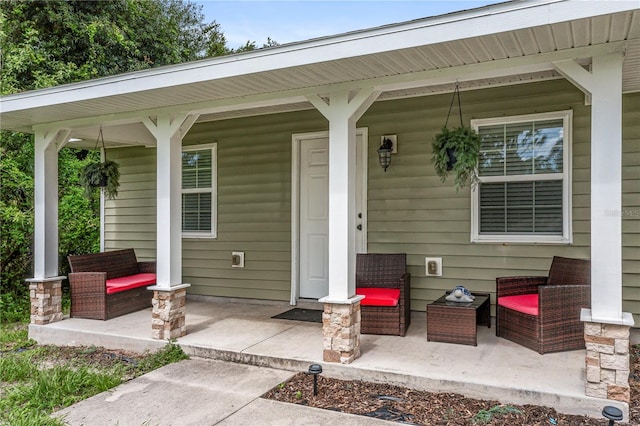 entrance to property featuring a porch and an outdoor hangout area