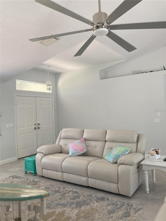 living room featuring lofted ceiling, ceiling fan, and a textured ceiling