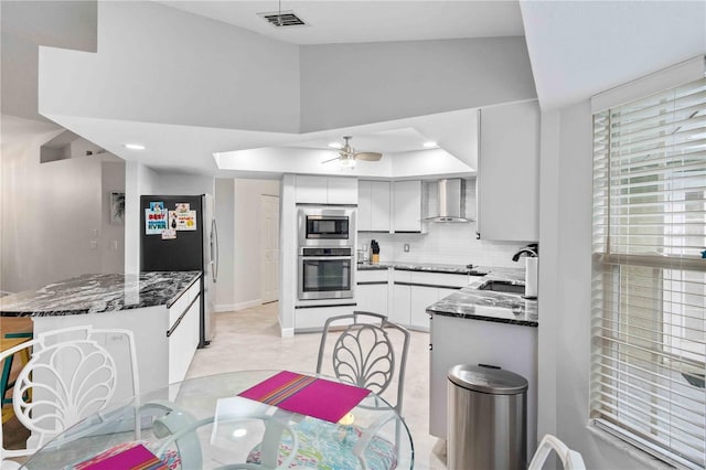 kitchen with white cabinets, wall chimney range hood, sink, backsplash, and built in microwave