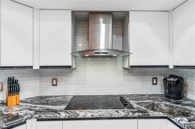 kitchen featuring white cabinets, backsplash, wall chimney range hood, and black electric cooktop