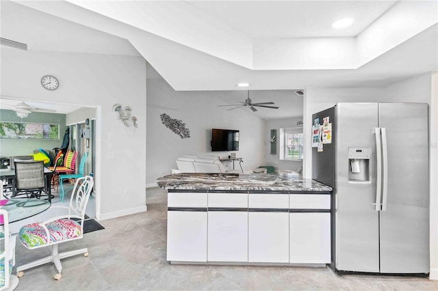 kitchen featuring stainless steel refrigerator with ice dispenser, ceiling fan, white cabinetry, and dark stone countertops