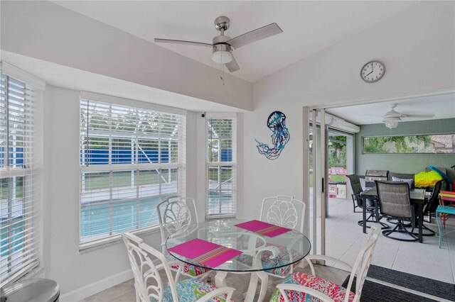 tiled dining area featuring ceiling fan and lofted ceiling