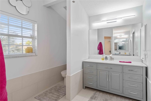 bathroom featuring tile walls, tile patterned floors, and vanity