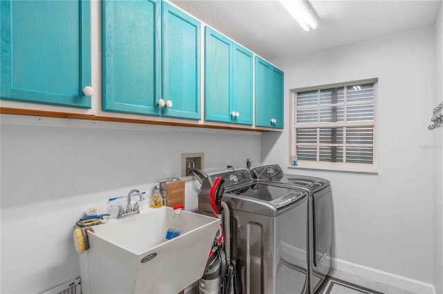 laundry room featuring sink, washer and dryer, and cabinets