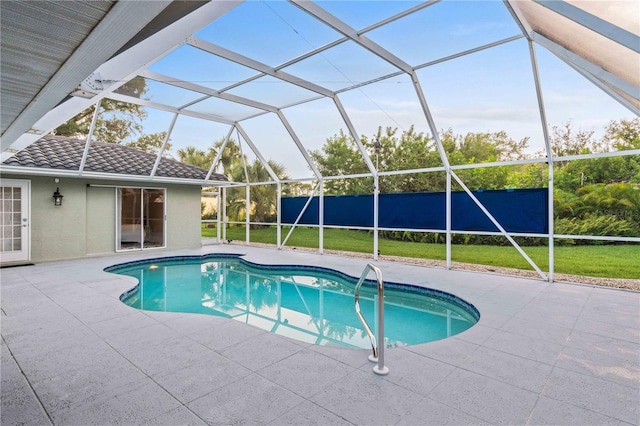 view of swimming pool with a lawn, a patio area, and glass enclosure