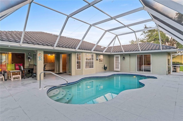 view of swimming pool with glass enclosure and a patio area