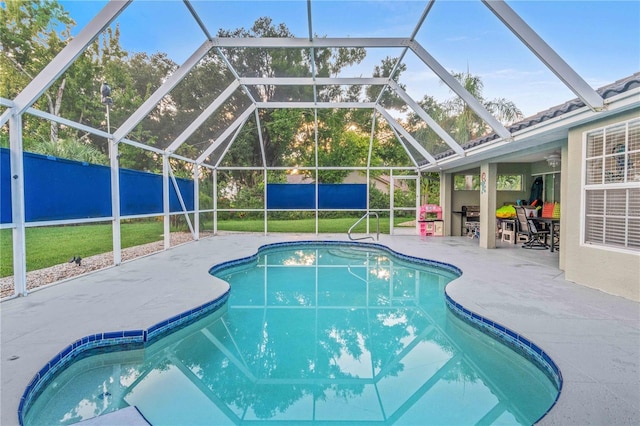 view of swimming pool featuring a patio area and a lanai