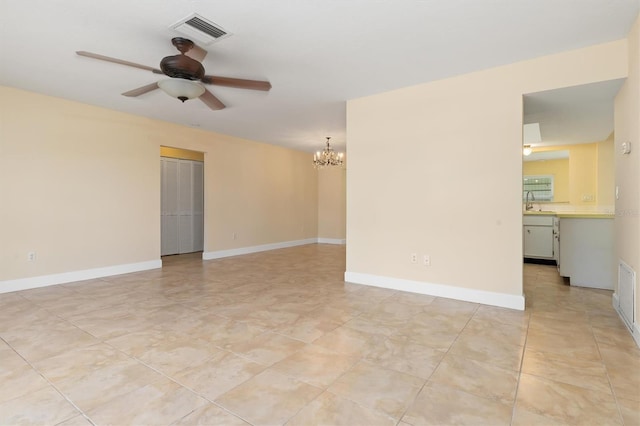 spare room featuring ceiling fan with notable chandelier