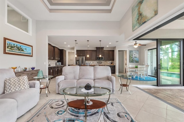 tiled living room with a raised ceiling and crown molding