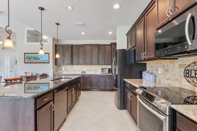 kitchen with dark brown cabinetry, appliances with stainless steel finishes, decorative light fixtures, and light stone countertops