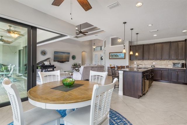 tiled dining area featuring beamed ceiling, ceiling fan, coffered ceiling, and sink