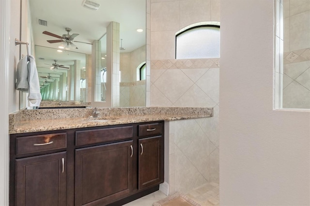 bathroom with vanity and a tile shower