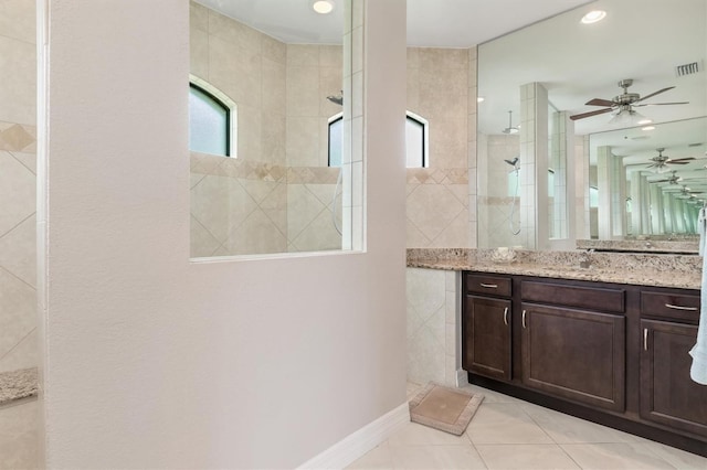 bathroom with vanity, tiled shower, and tile patterned floors