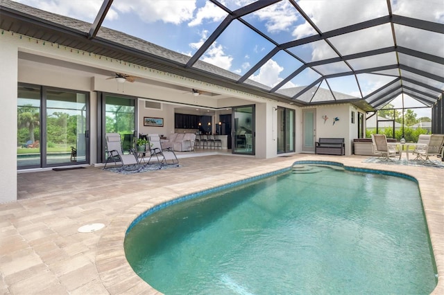 view of pool with a lanai, ceiling fan, and a patio area