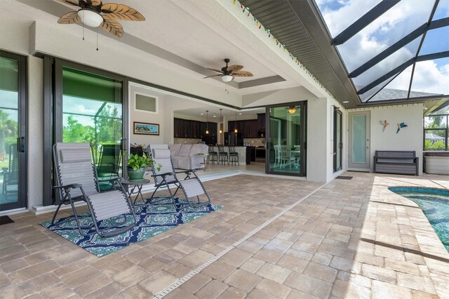 view of patio / terrace with ceiling fan and a lanai