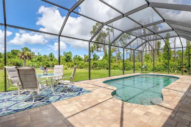 view of pool with a patio area, glass enclosure, and a lawn