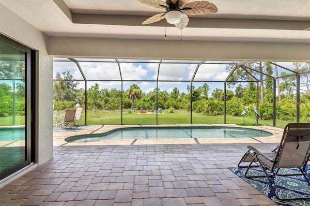 view of pool with ceiling fan, a lanai, a patio area, and a lawn